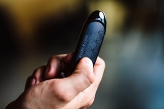 A hand holding the Seed & Smith Dart vaporizer, showing how the vape is small and discreet.