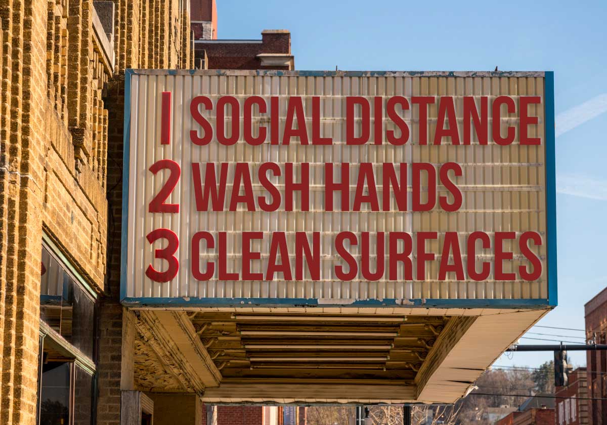 Stock photo of old fashioned theater billboard that says: 1 - Social Distance; 2 - Wash Hands; 3 - Clean Surfaces