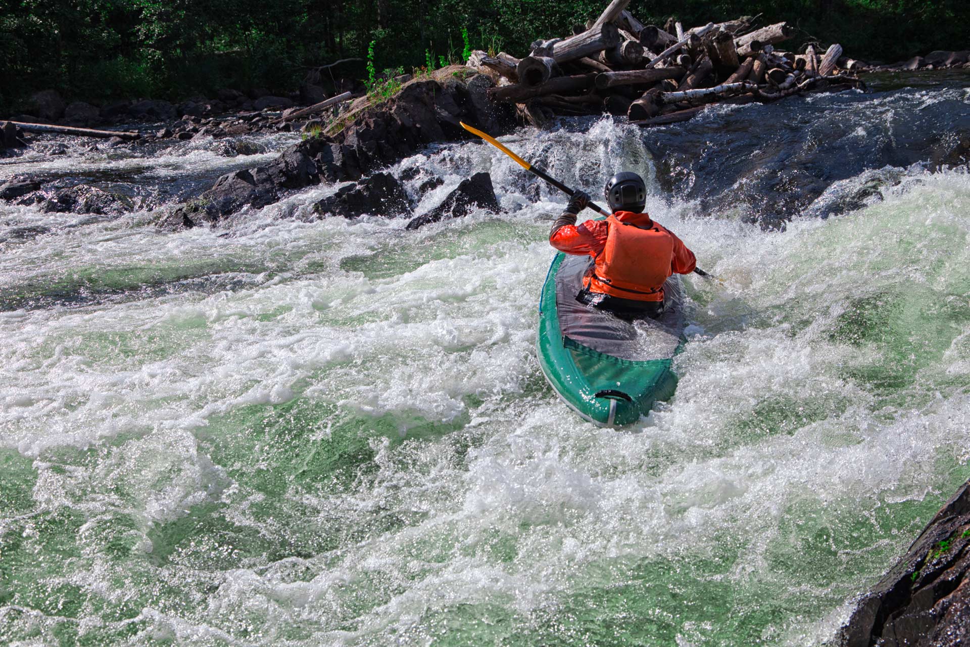 Solo kayaker navigating rapids, representing the effort and skill needed to navigate the cannabis industry.