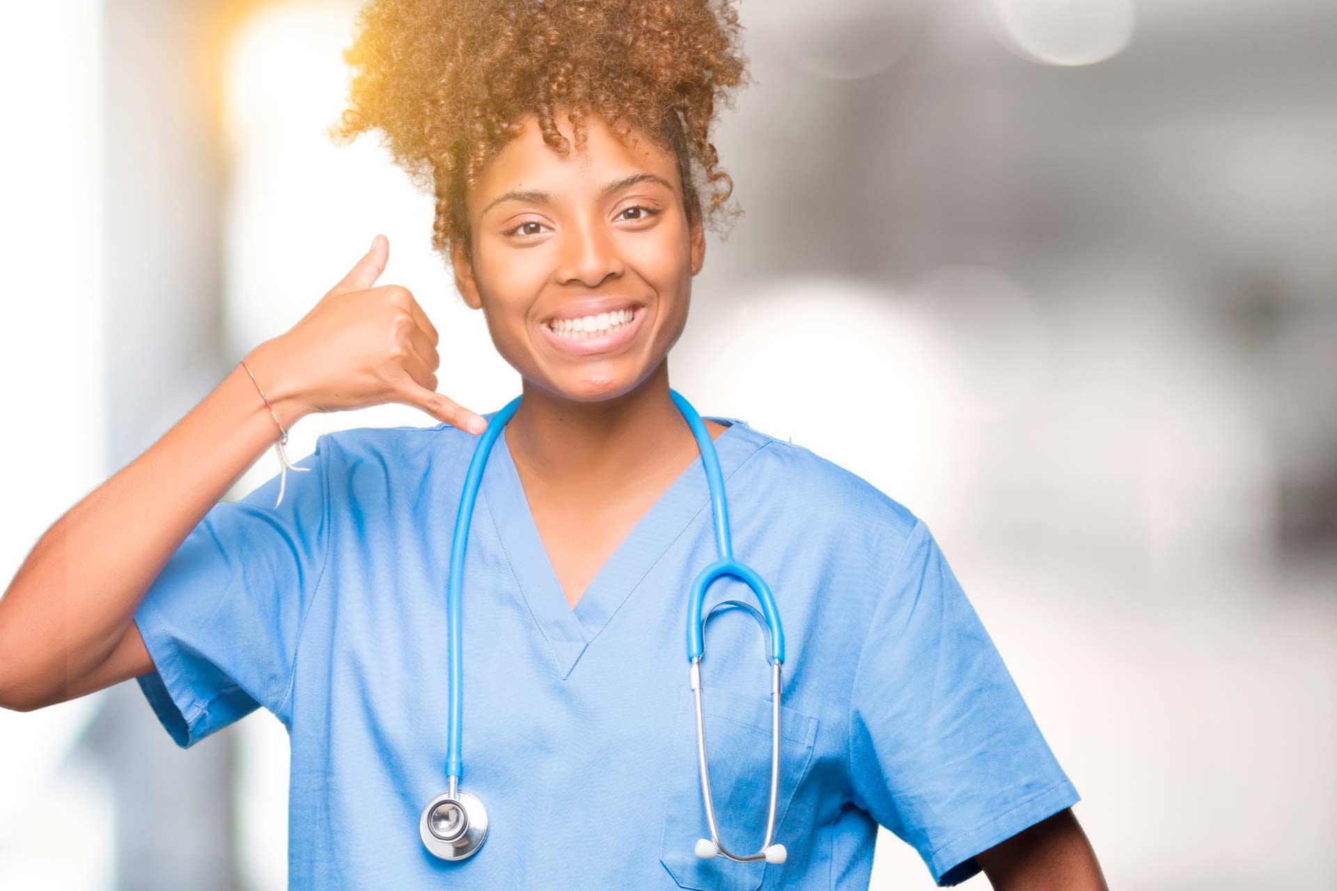 Smiling African-American nurse in blue scrubs making a phone symbol with her hand, reminding readers that the Leaf411 hotline welcomes your calls.