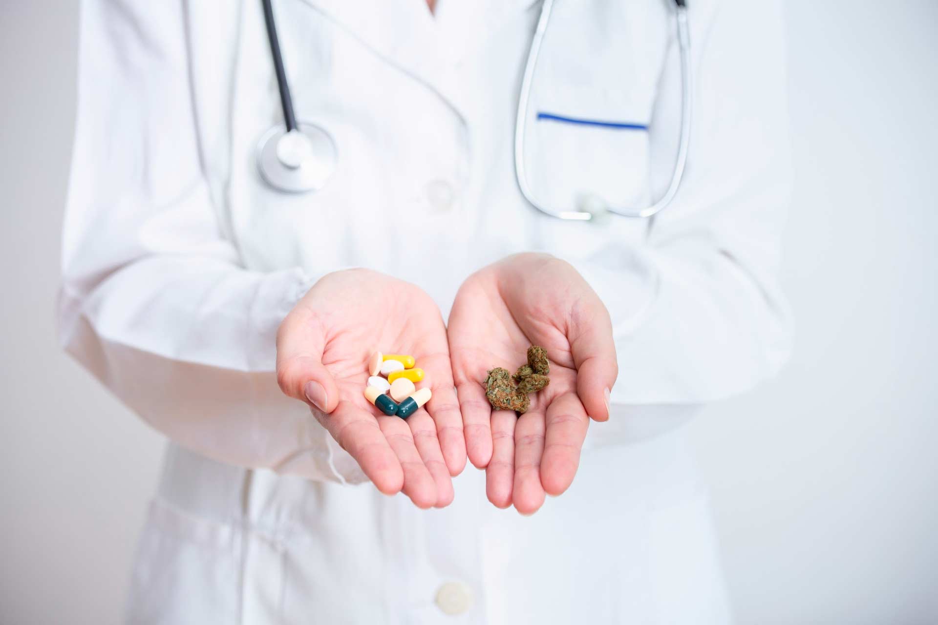 Medical provider holding sleep pills in one hand, and cannabis in the other hand as an alternative for sleep.