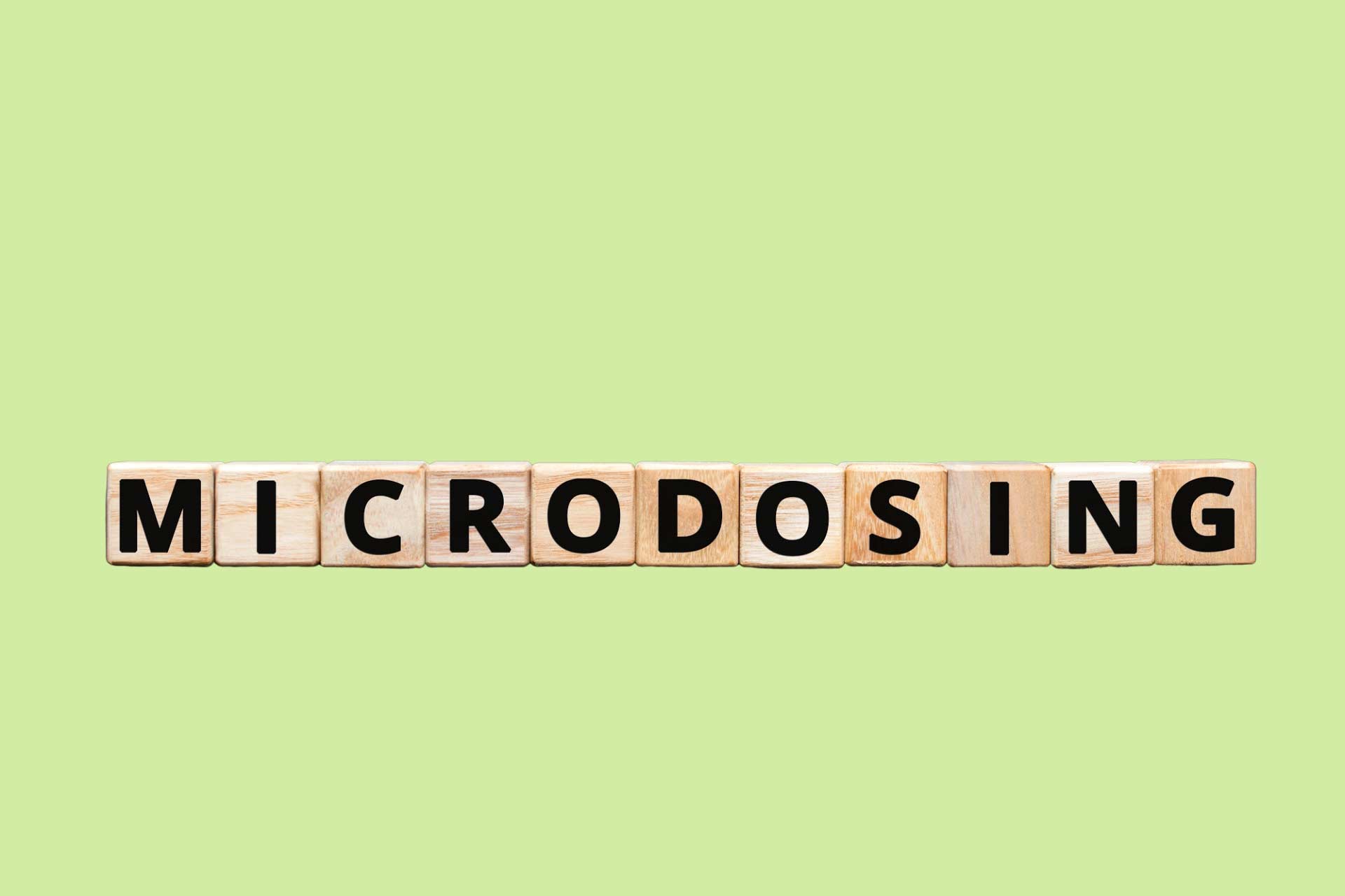 Wooden letter blocks spelling out “Microdosing” referencing microdosing THC for relief.