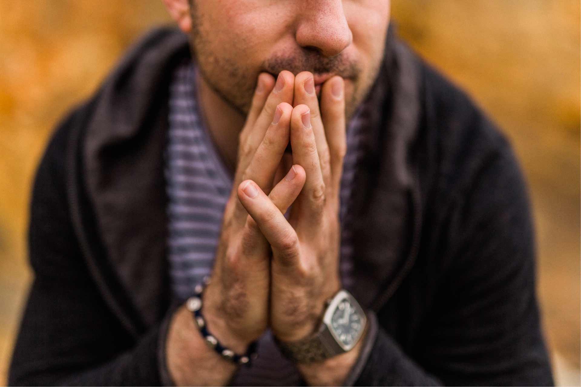 Close-up of man’s hands as he contemplates pros and cons of a medical marijuana card.