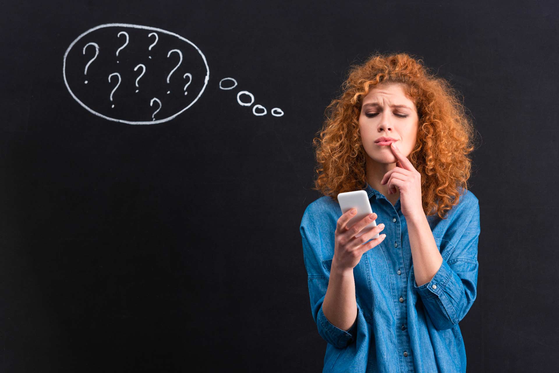 Woman holding phone looking at screen with questioning expression, with question mark thought bubble