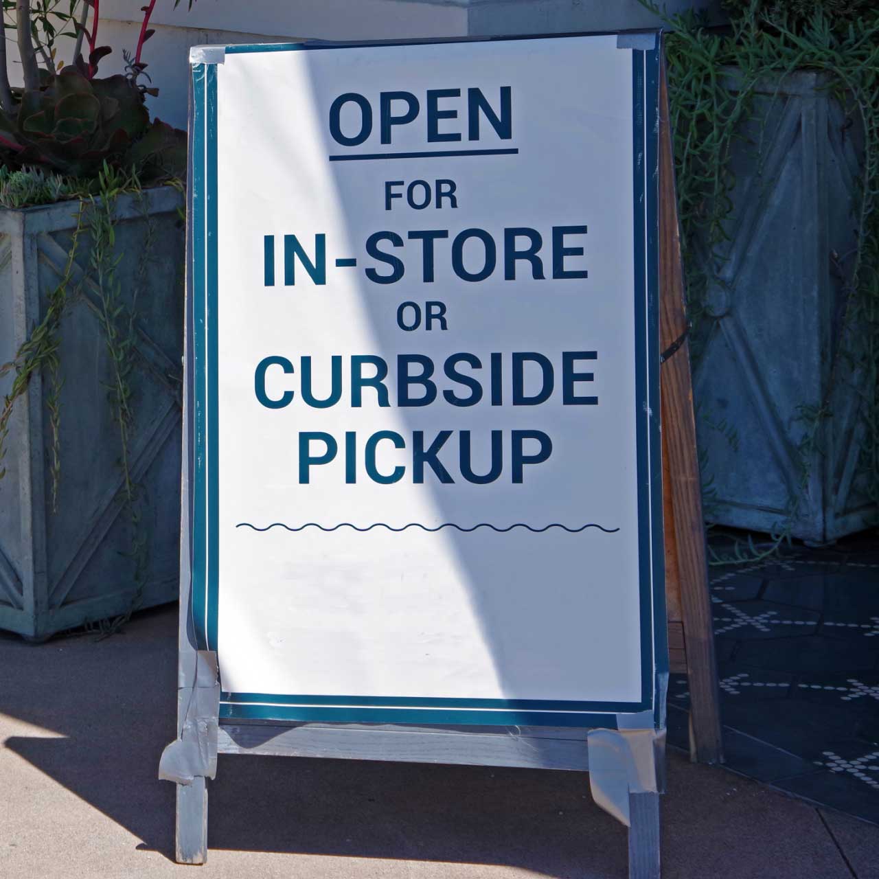 Cannabis dispensary store sign saying “Open for in-store or curbside pickup.”