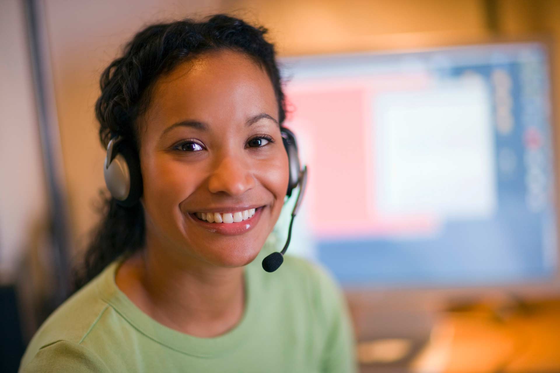 Smiling nurse with a phone headset on, ready to answer callers’ medical marijuana questions.