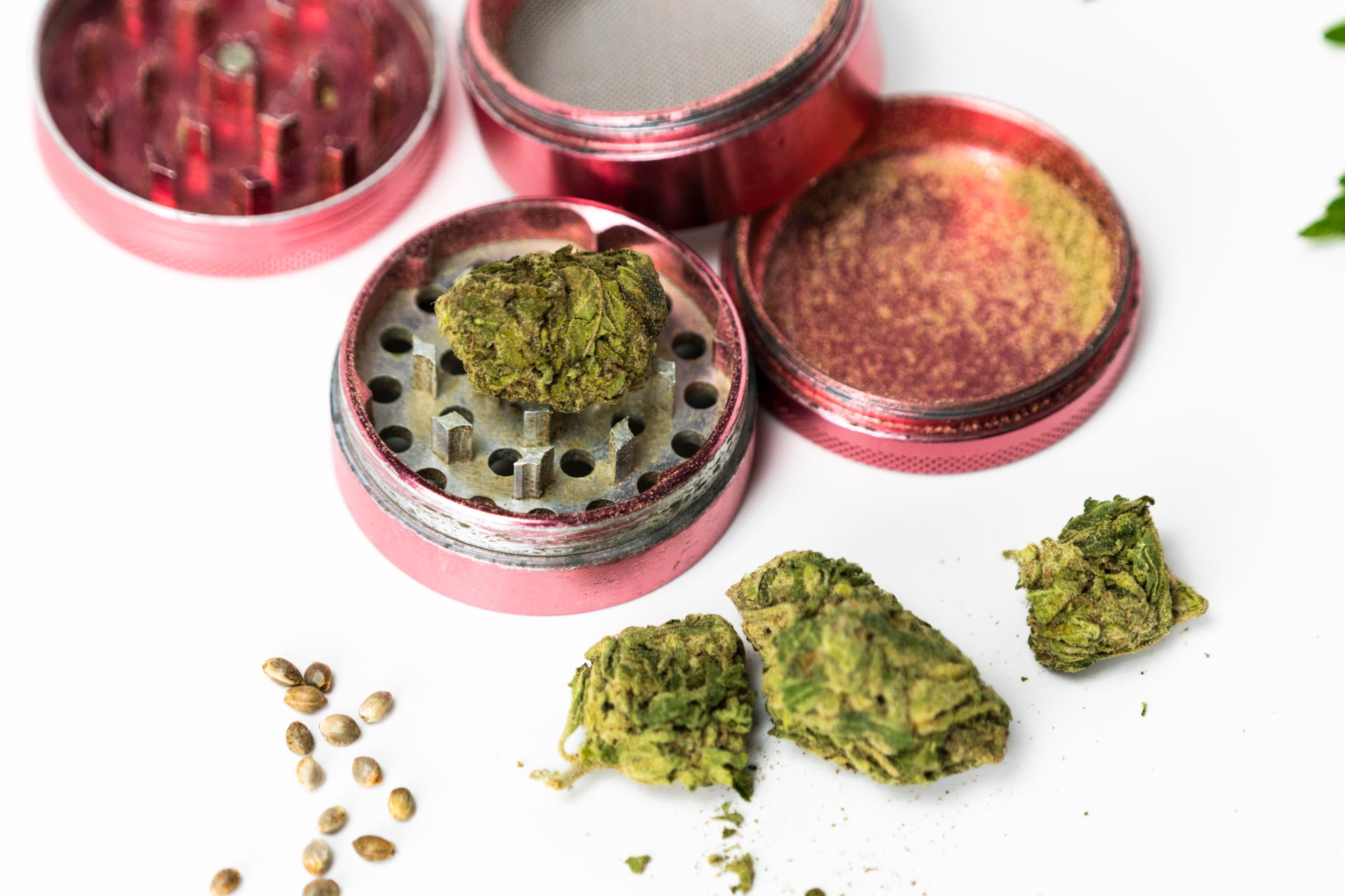 Herb grinder designed for cannabis flower. Kief is shown in the compartment on the right side, after passing through the screen in the multi-chambered flower grinder.