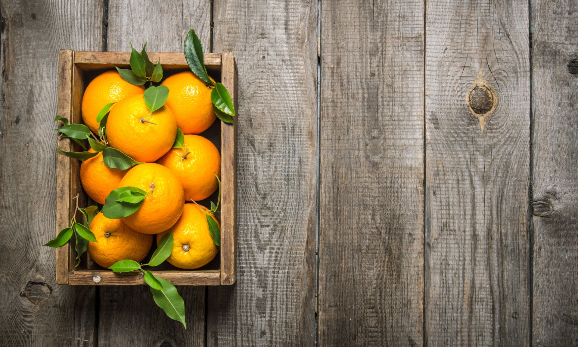 Freshly picked oranges in a fruit crate, mirroring Myriam’s Hemp’s newest Sunshine Orange flavor.