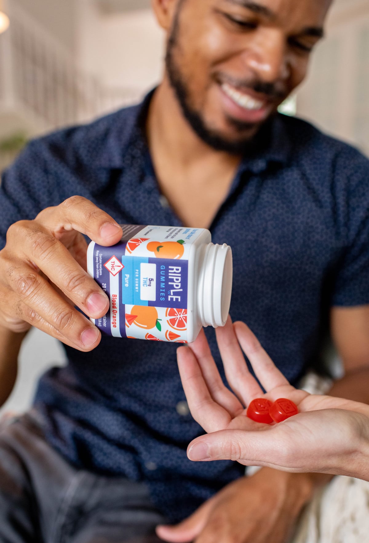 A man shares two cannabis-infused Ripple Gummies with a friend.