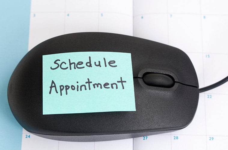 Computer mouse with sticky note that says “Schedule Appointment” for Leaf411 cannabis nurse consultation.